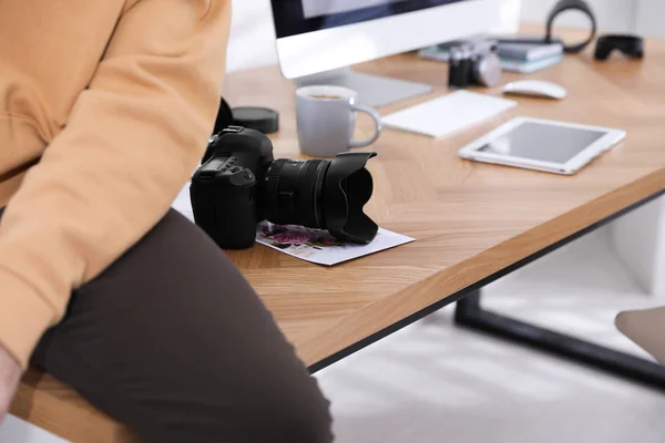 Профессиональный фотограф работает в офисе, фокусируется на фотоаппарате — стоковое фото