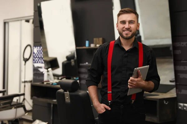 Young business owner with tablet in barber shop — Stock Photo, Image