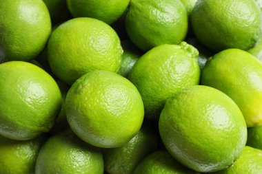 Arka plan olarak taze yeşil limonlar, üst görünüm