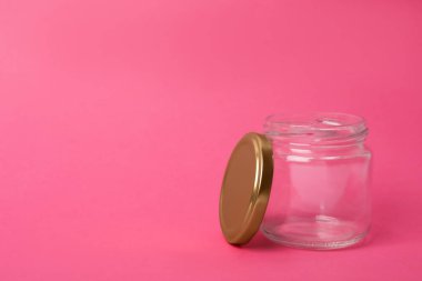Boş cam kavanozu pembe arkaplanda aç, metin için boşluk