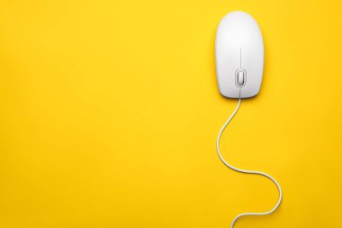 Sarı arka planda kablolu bilgisayar faresi, üst görüntü. Metin için boşluk