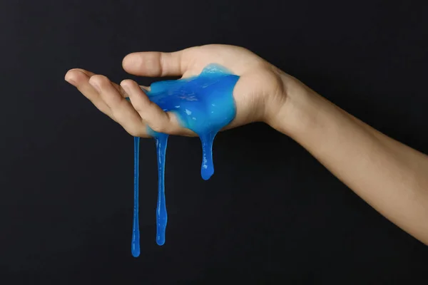 Woman playing with blue slime on black background, closeup. Anti — 스톡 사진
