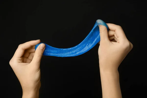 Woman playing with blue slime on black background, closeup. Anti — Stock Photo, Image