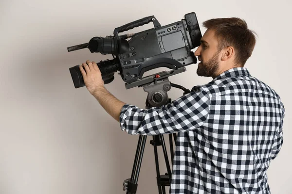 Operador com câmera de vídeo profissional em fundo branco — Fotografia de Stock