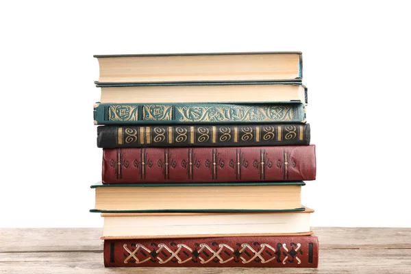 Montón de libros antiguos de época sobre mesa de madera contra fondo blanco —  Fotos de Stock