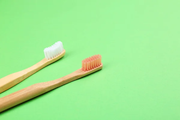 Escovas de dentes de bambu naturais em fundo verde. Espaço para texto — Fotografia de Stock