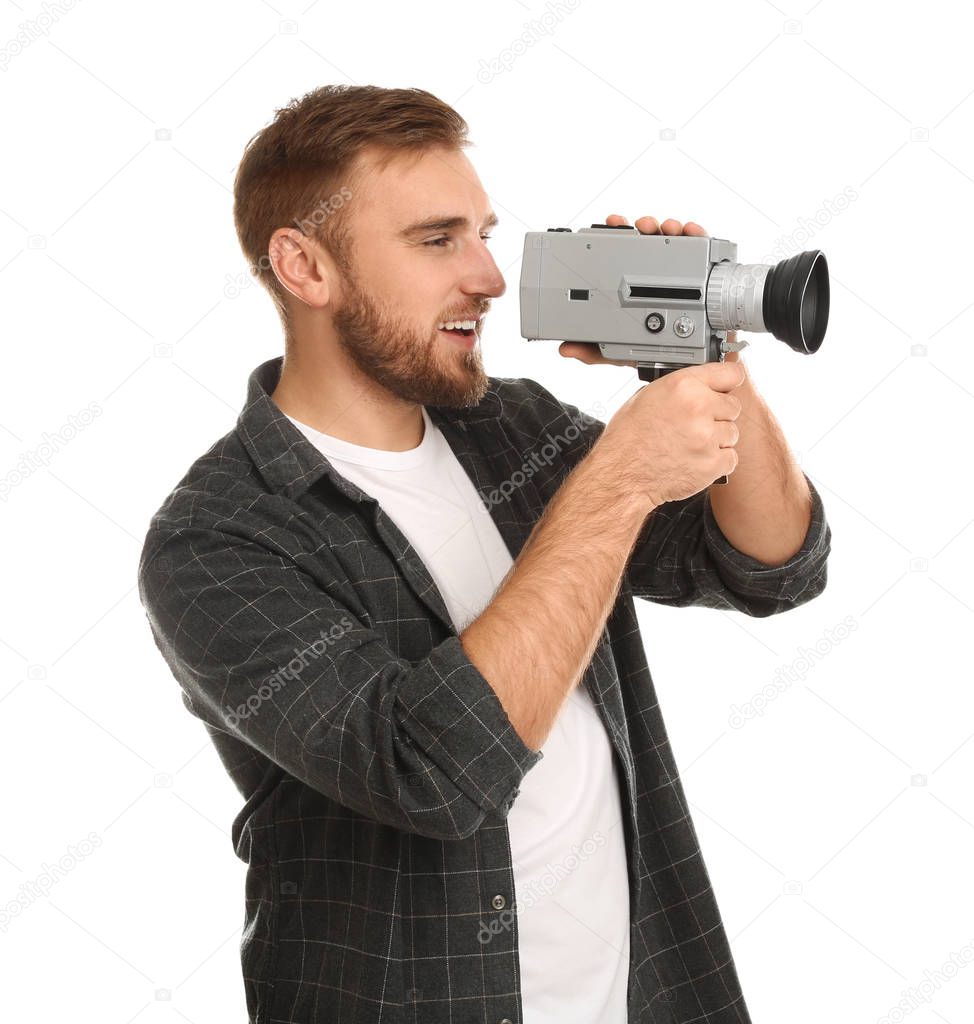 Young man with vintage video camera on white background