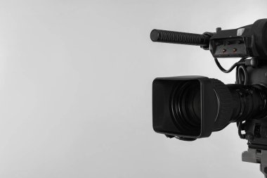 Işıklı arka planda modern profesyonel video kamera. Metin için boşluk