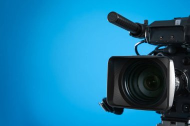 Mavi arka planda profesyonel video kamera, yakın plan. Metin için boşluk