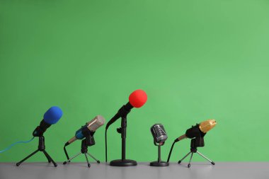 Microphones on table against green background. Journalist's work clipart