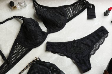 Açık gri arka planda kadın iç çamaşırlarıyla düz bir kompozisyon.