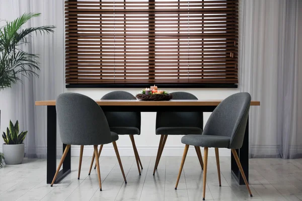 Mesa de madeira moderna com velas em chamas no interior do quarto — Fotografia de Stock