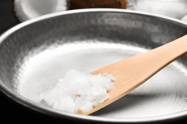 Frying pan with coconut oil and wooden spatula, closeup. Healthy — Stock Photo, Image