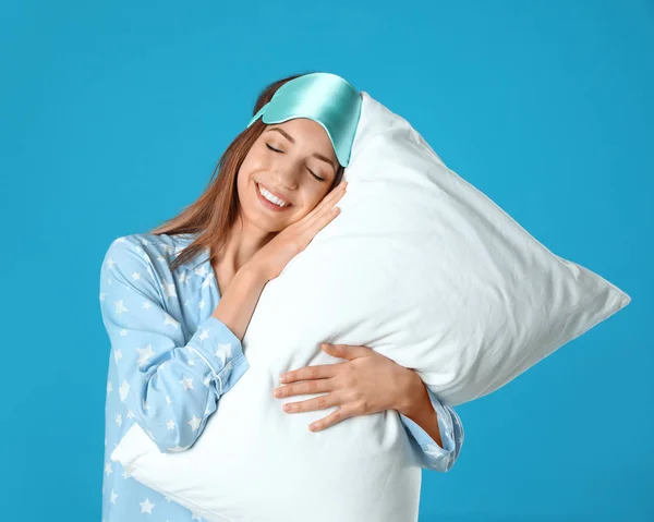 Hermosa mujer con almohada sobre fondo azul claro. Hora de dormir —  Fotos de Stock