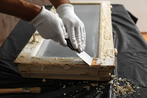 Homem reparando janela danificada velha na mesa dentro de casa, close-up — Fotografia de Stock