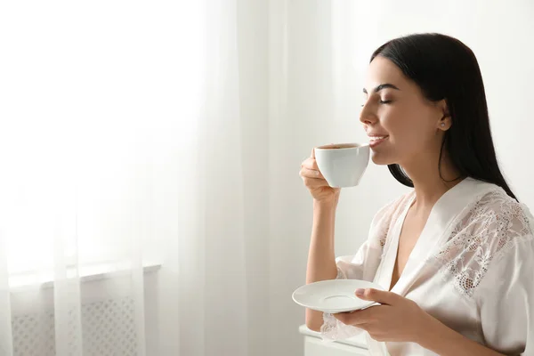 Egy nő egy csésze kávéval a hálószobában. Lusta reggel. — Stock Fotó
