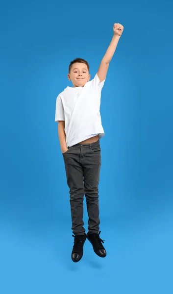 Preteen boy jumping on light blue background — 스톡 사진