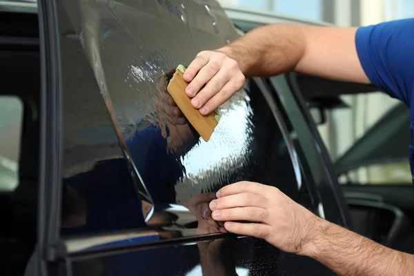 Obrero teñido ventana del coche con papel de aluminio en el taller, primer plano —  Fotos de Stock