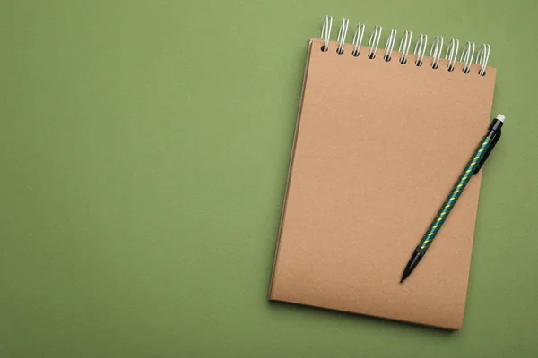 Caderno Kraft Lápis Sobre Fundo Verde Vista Superior Espaço Para — Fotografia de Stock