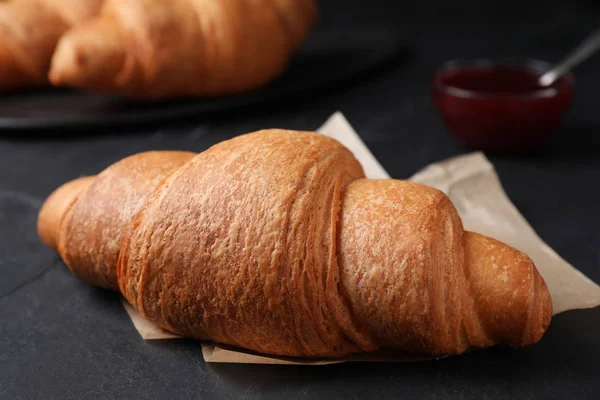 Tasty fresh croissant on black table, closeup — 스톡 사진
