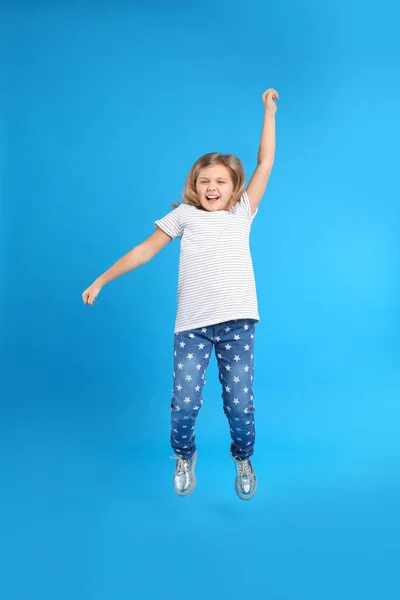 Açık Mavi Arka Planda Atlayan Sevimli Küçük Kız — Stok fotoğraf