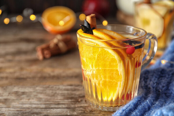 Aromatic mulled wine on wooden table, closeup. Space for text