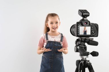 Beyaz arkaplanda video kaydeden sevimli küçük blogger
