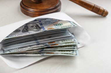 Dolar banknotları ve tokmak açık gri taş masa, yakın plan. Rüşvet kavramı