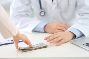 Hasta klinikteki doktora rüşvet veriyor, yakın plan. Yozlaşmış tıp