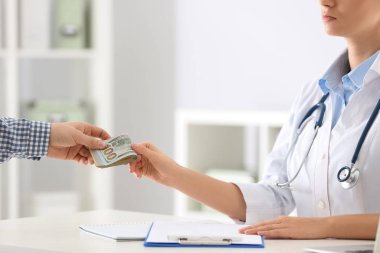 Hasta klinikteki doktora rüşvet veriyor, yakın plan. Yozlaşmış tıp