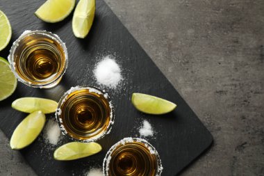Meksika tekila shot 'ı, tuz ve limon ile gri masa, üst manzara.