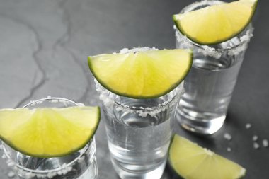 Meksika tekila shot 'ı, limon dilimleri ve masaya tuz, yakın plan.