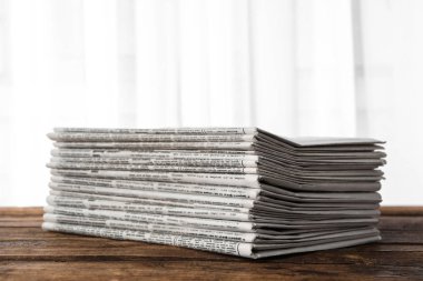 Tahta masadaki gazete yığını. Gazeteci işi.