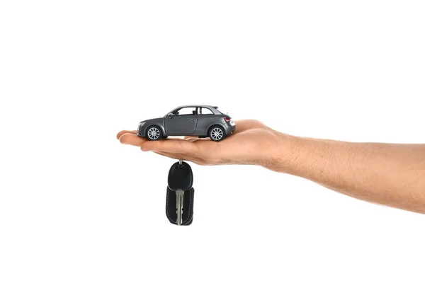 Man holding key and miniature automobile model on white backgrou — Stock Photo, Image