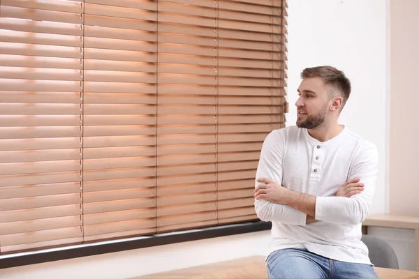 Joven guapo cerca de la ventana en casa — Foto de Stock