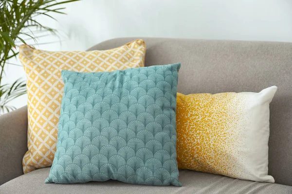 Different soft pillows on sofa in living room — Stock Photo, Image