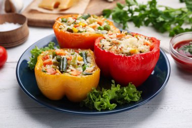 Beyaz ahşap masada servis edilen dolma dolma dolma biberler.