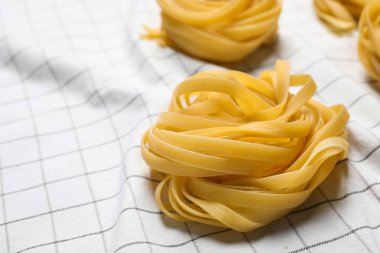 Beyaz masa örtüsü üzerinde Tagliatelle makarnası, yakın çekim görünümü