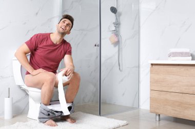 Tuvaletteki tuvalet kağıdına sarılmış bir adam.