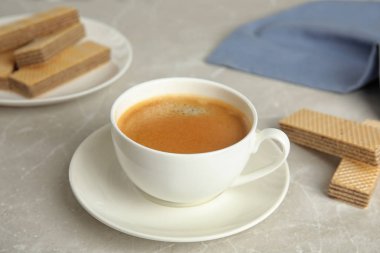 Gri mermer masada kahvaltı için lezzetli kahve ve gofretler.