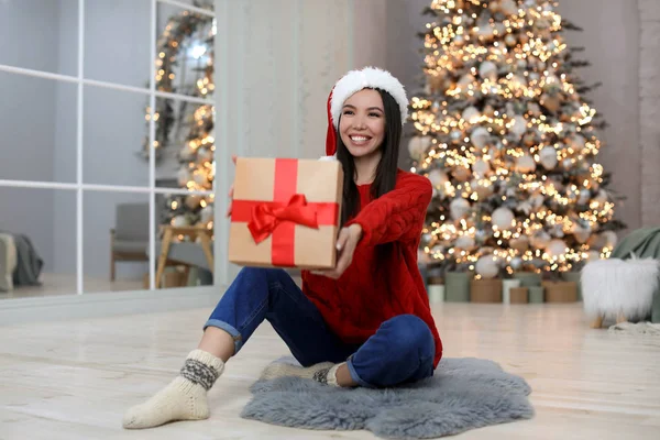 Счастливая Молодая Женщина Шляпе Санта Рождественским Подарком Дома — стоковое фото