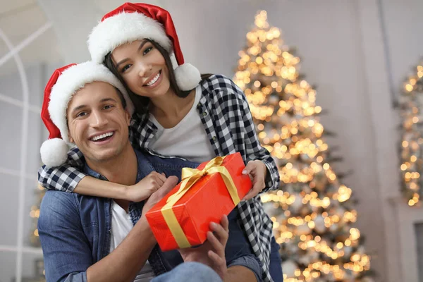 Noel Baba Şapkalı Mutlu Çift Evde Noel Hediyesiyle — Stok fotoğraf