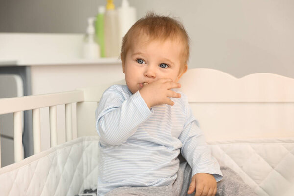 Cute little baby in crib at home