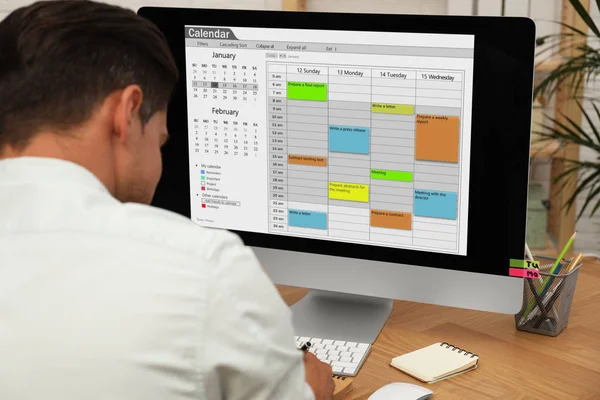Homem usando aplicativo calendário no computador no escritório, close-up — Fotografia de Stock