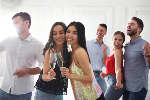 Couple of happy friends with champagne dancing at party — Stock Photo, Image