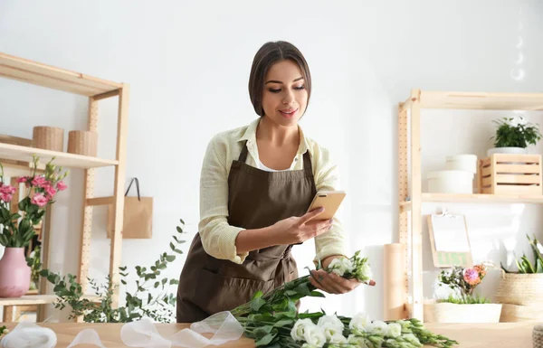 Floristería tomando fotos de hermosas flores en el taller — Foto de Stock