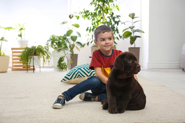 Маленький хлопчик з цуценям на підлозі вдома. Дружній собака — стокове фото