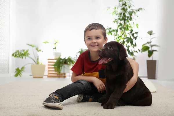 Little boy with puppy on floor at home. Friendly dog — 스톡 사진