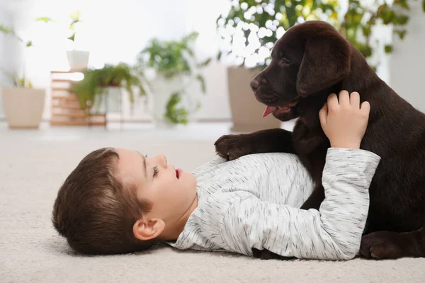 Kleiner Junge mit Hund zu Hause auf dem Boden liegend — Stockfoto