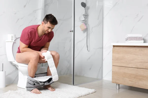 Tuvaletteki Klozette Mide Ağrısı Çeken Kağıt Rulolu Bir Adam — Stok fotoğraf